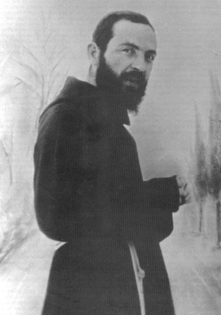 Man in dark robe with a beard.