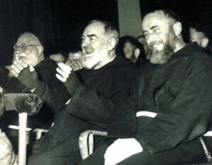 Older bearded man seated with younger man