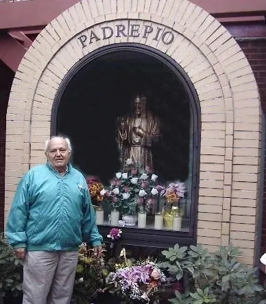 Man standing by Padre Pio shrine.