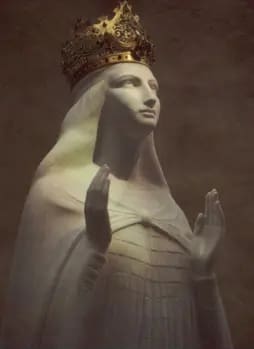 Statue of crowned figure with raised hands.