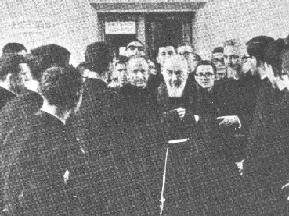 Group of people gathered around a figure.