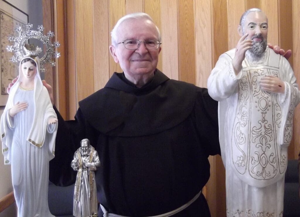 Man holding religious statues of saints.