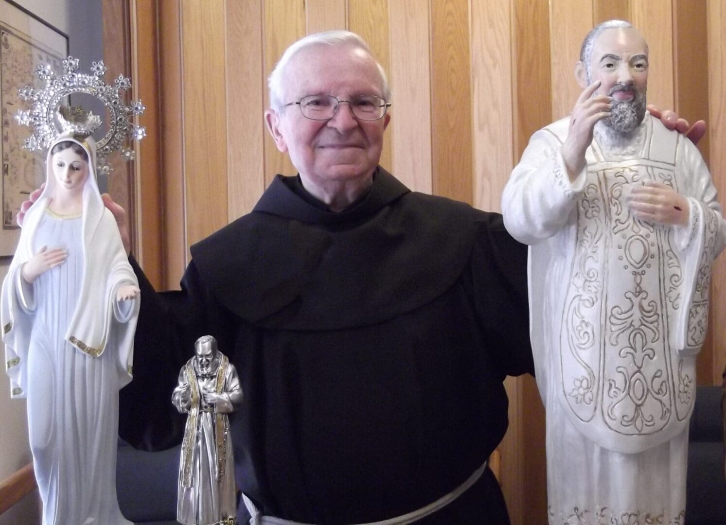 Man holding religious statues of saints.