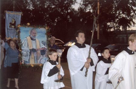 A group of people in white robes holding sticks.