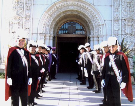 A group of men in suits and hats standing outside.
