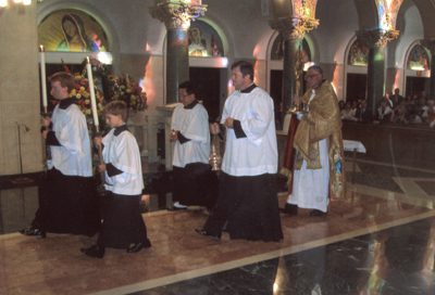 A group of people in white robes walking through a room.