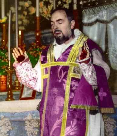 A man in purple and yellow outfit holding a cross.