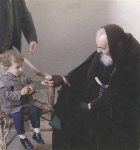 A man in black robe holding a child 's hand.