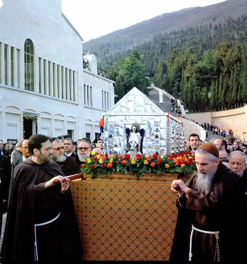 A group of people in black robes standing around a large box.