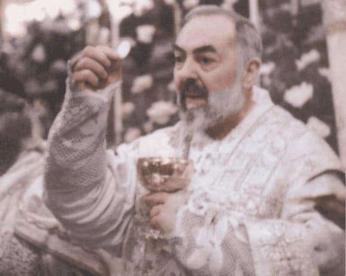 A man in white shirt holding fork and glass.