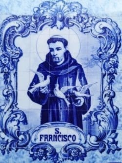 A tile mural of st. Francis with birds in the frame