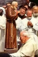 A group of men in white robes and one man is wearing a brown robe.