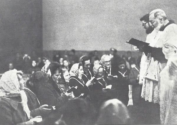 A man in white is holding a book