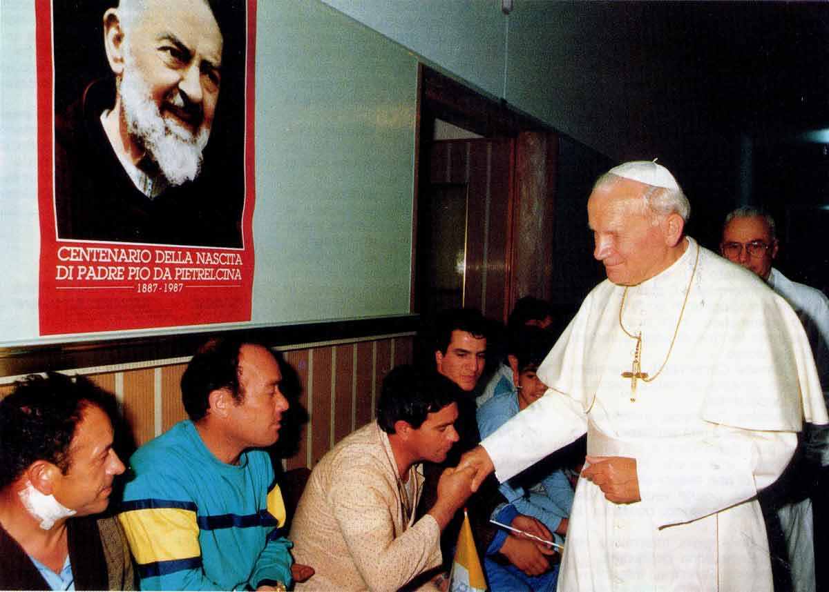 A man in white shirt standing next to two men.