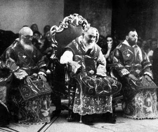 A group of men sitting in chairs and wearing robes.