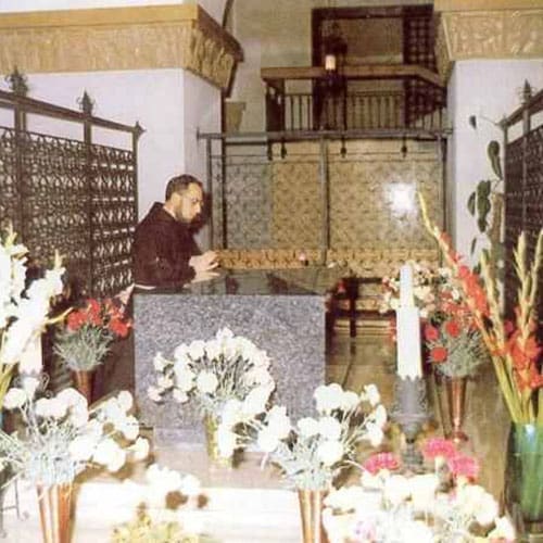 A man standing in front of a table with flowers.
