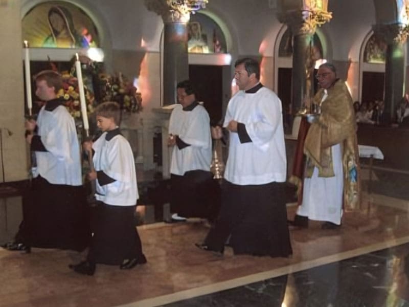 A group of people in white robes walking on the floor.