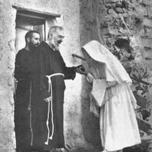 A nun is handing something to two men.