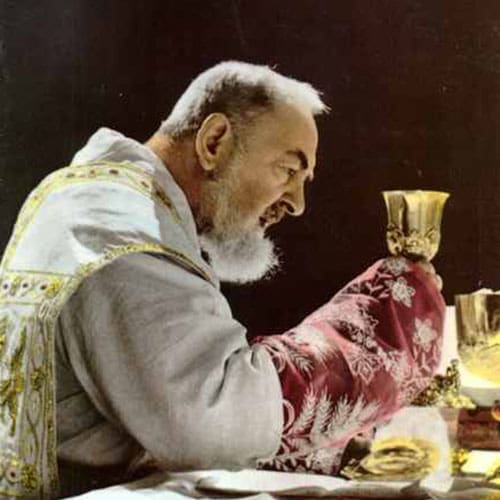 A man sitting at the table with his hands on his face.