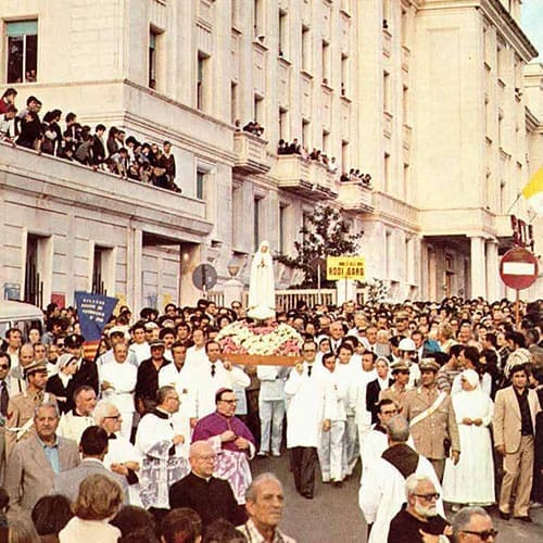A crowd of people in white clothes and some are standing.
