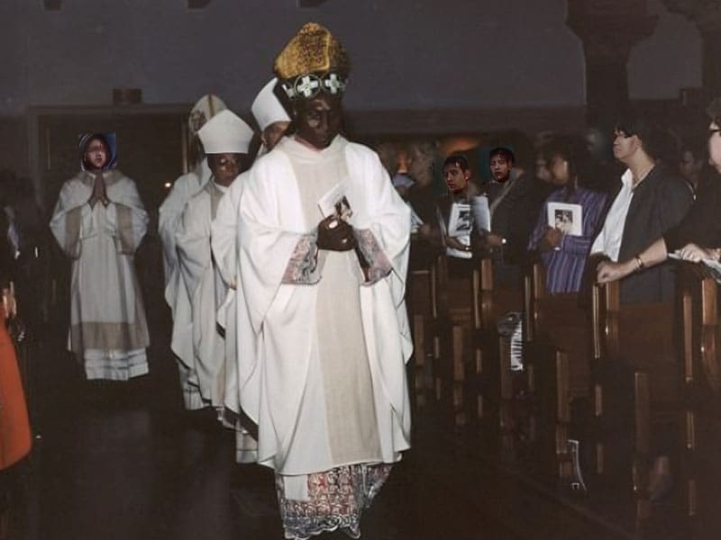 A group of people in white robes and hats.