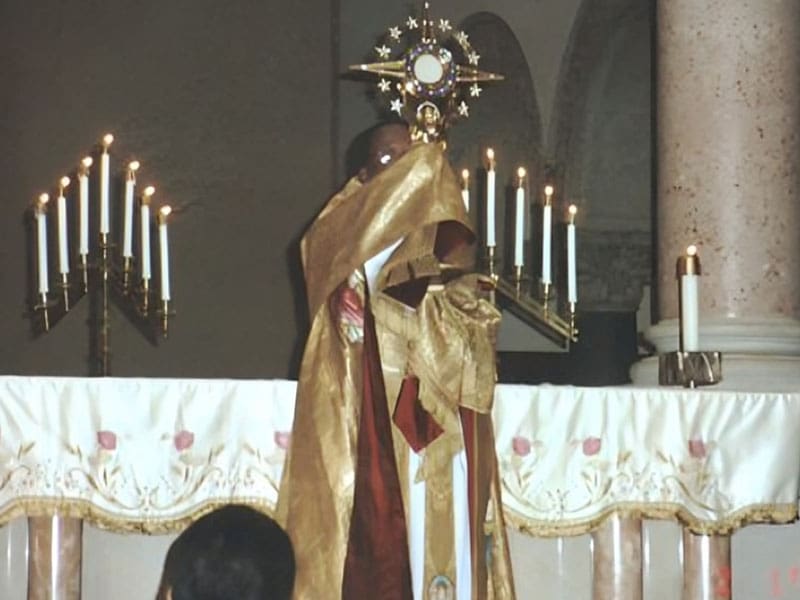 A priest in gold robes standing at the altar.