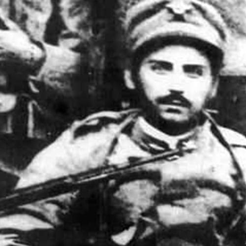 A man in military uniform holding a rifle.