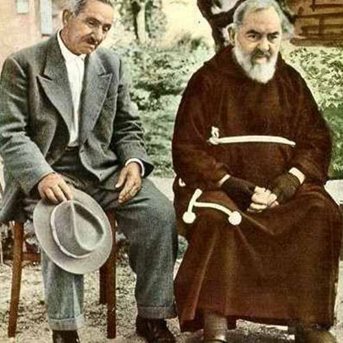 A man sitting next to another man in a suit.