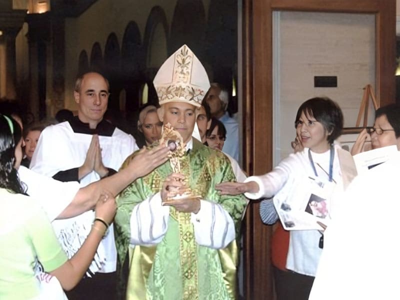 A priest is surrounded by people in robes.