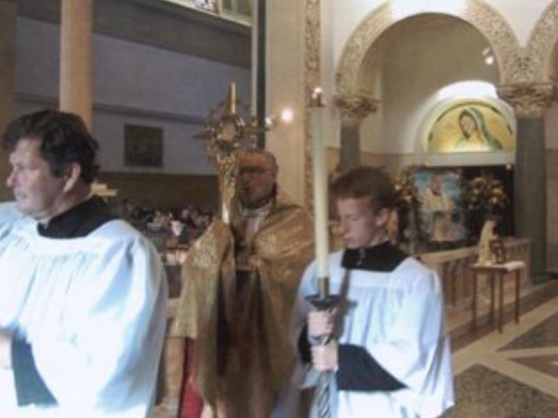 A priest and two men in white robes