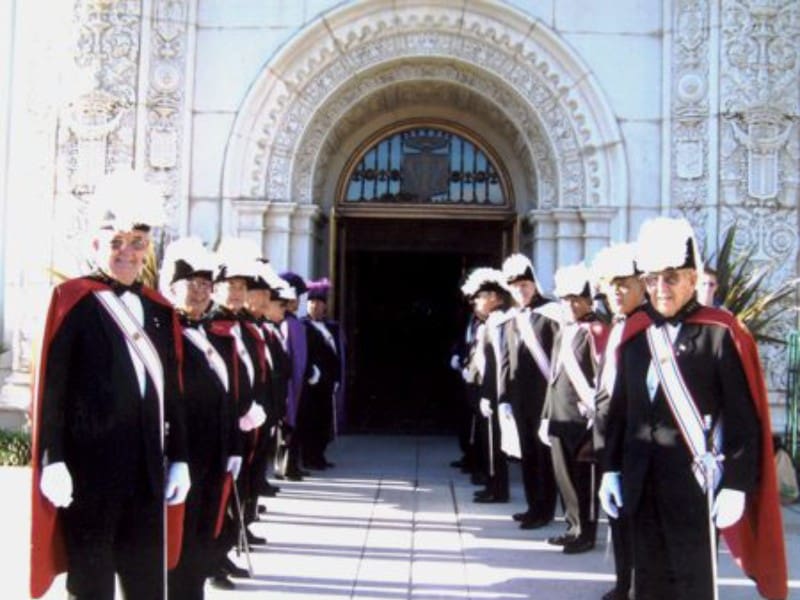 A group of men in suits and hats standing outside.