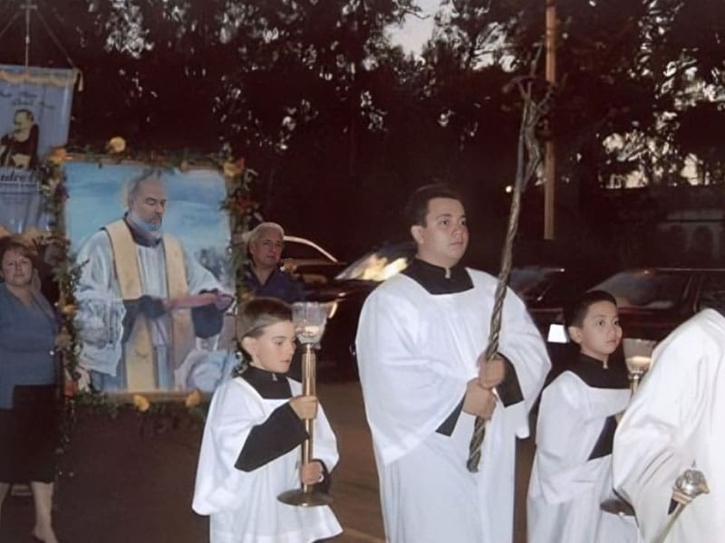 A group of people in white robes holding torches.