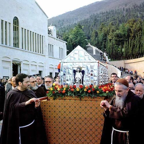 A group of people in black robes standing next to a basket.