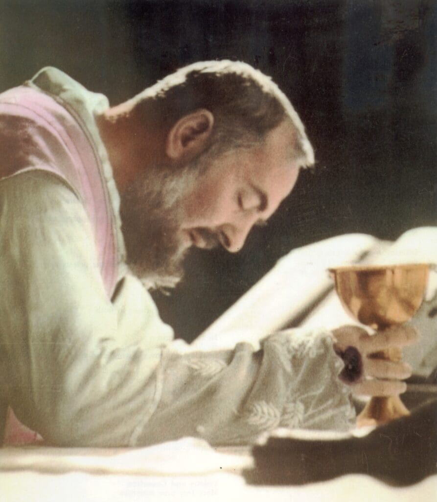 Priest holding a chalice in prayer.