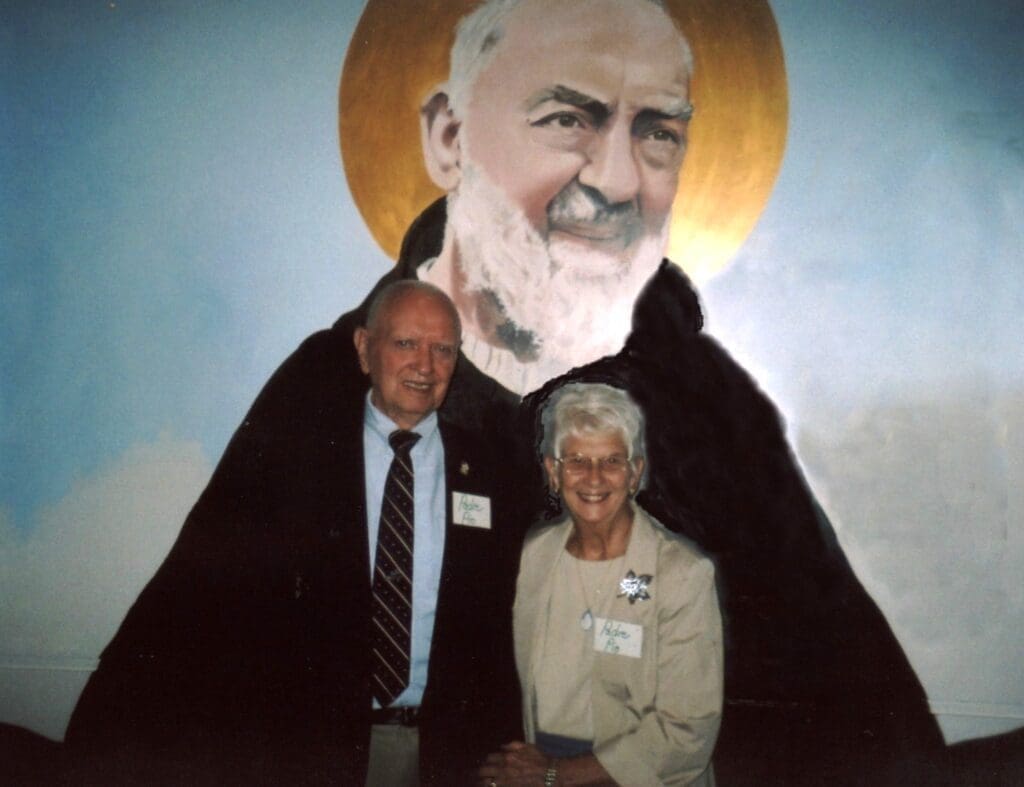 Elderly couple posing in front of mural.