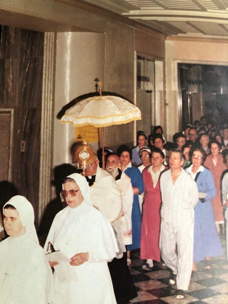 Religious procession with nuns and clergy indoors.