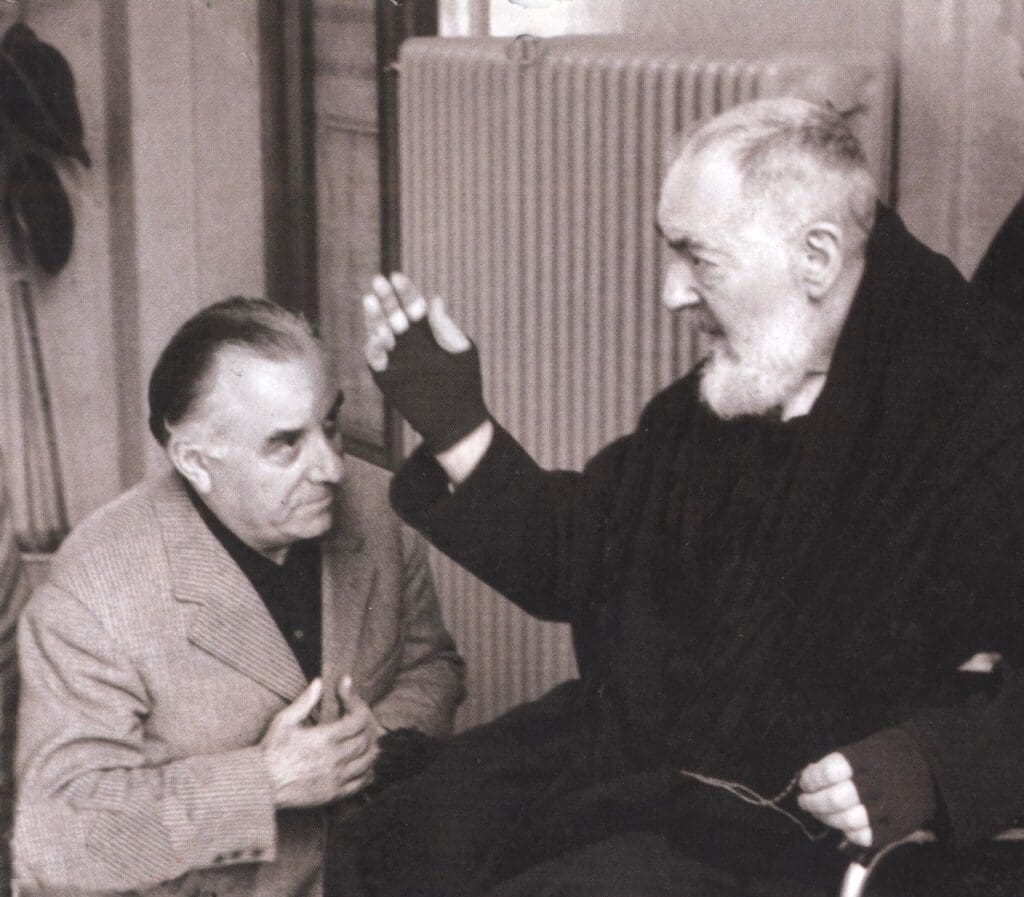 Elderly man gesturing to seated man.