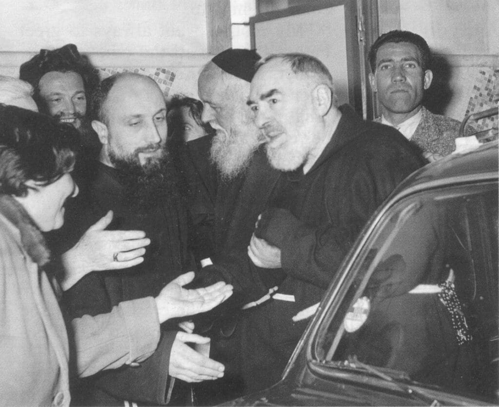 Group of men in conversation near car.