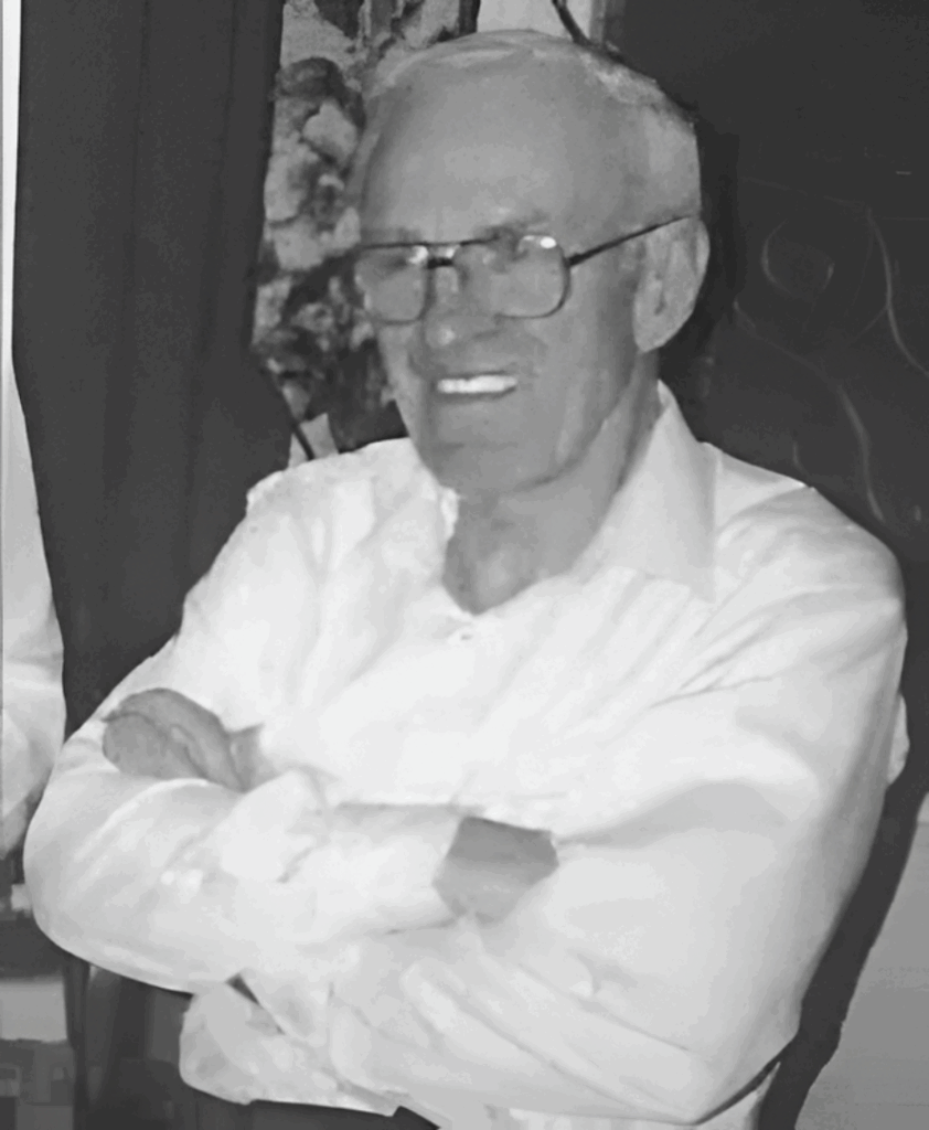 Elderly man smiling with arms crossed.