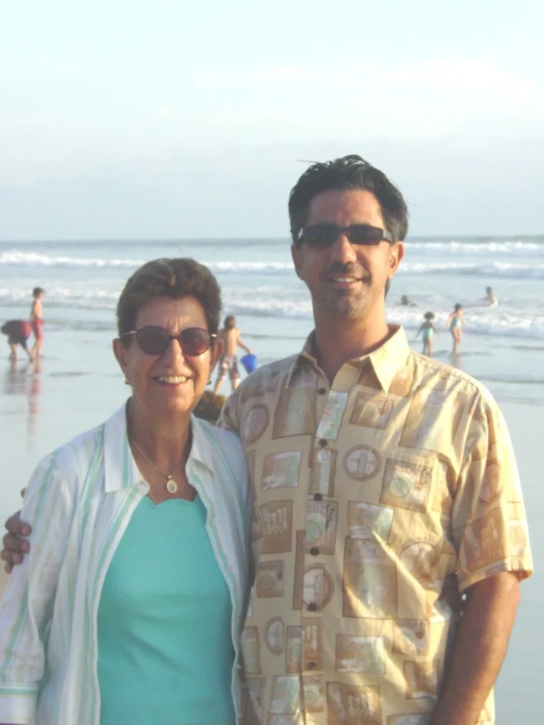 Couple smiling on a sunny beach.
