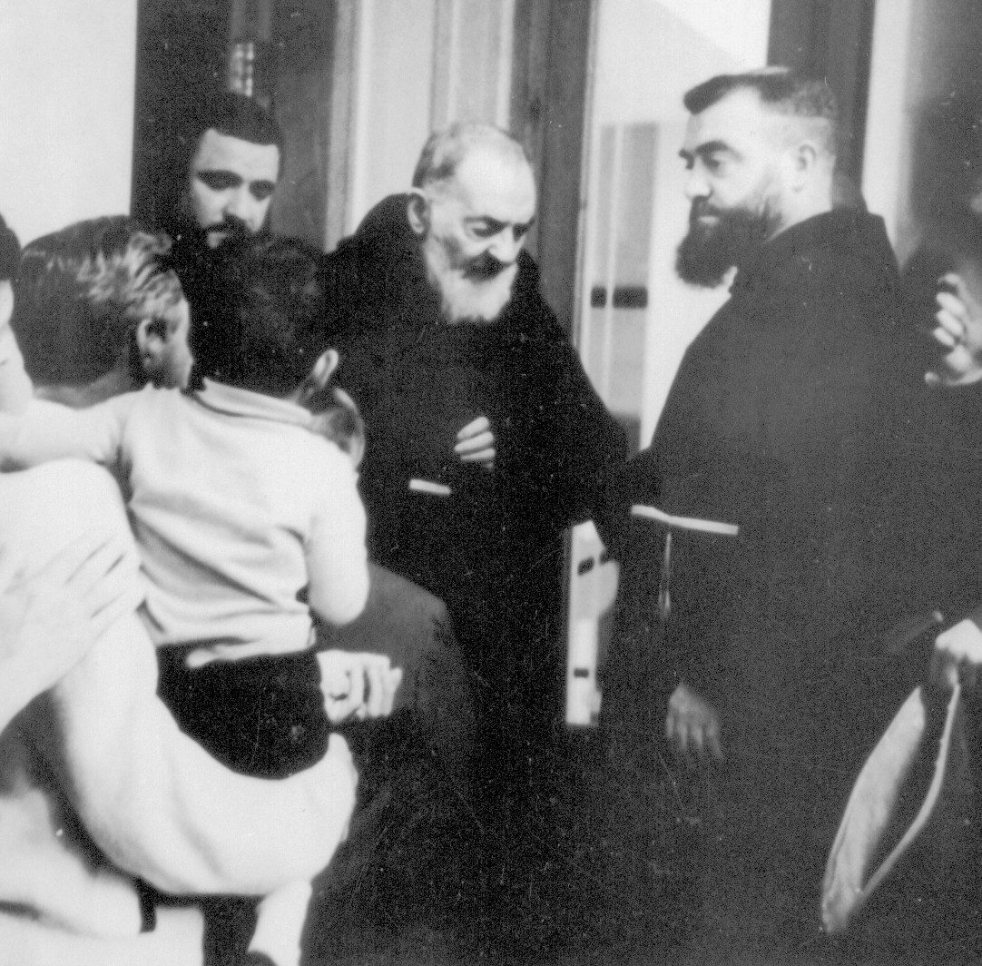 Emelio Noriega with his son in his arms, greets Padre Pio.