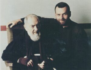 Older bearded man seated with younger man